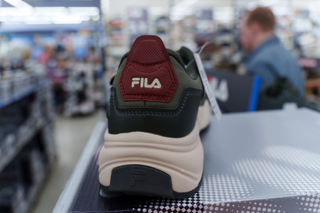 Tyumen, Russia-August 11, 2024: Fila sneaker is prominently displayed with detailed lacing and a visible brand tag, viewed inside a retail shop.のeditorial素材
