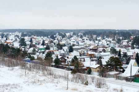Snow blankets a quaint village, creating a tranquil winter wonderland at duskの写真素材