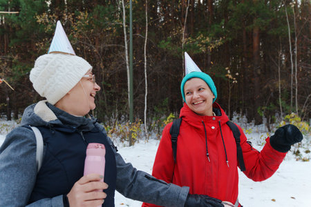 Winter celebration in the woods with friends wearing festive hats and enjoying the snowy landscape