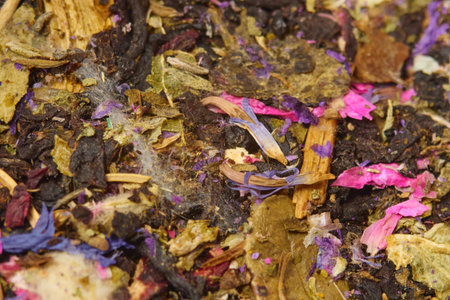 A vibrant mixture of dried herbs and flowers is spread out on a wooden table, showing various colorsの写真素材