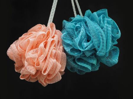 Brightly lit washcloths pink and blue on ropes isolated on a black background