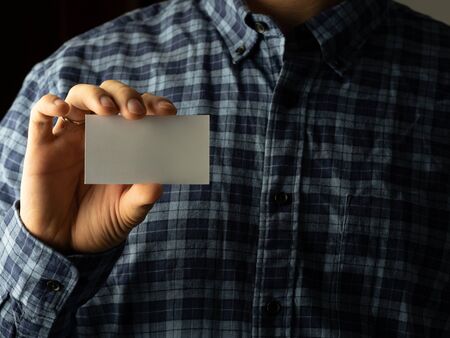 a man in a plaid shirt puts a business card in his shirt pocket. copy spaceの写真素材