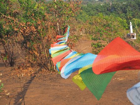 close up blurry multicolored Buddhist flags with mantras flutter in the wind