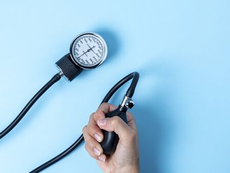a woman's hand holds a blood pressure monitor that shows blood pressure
