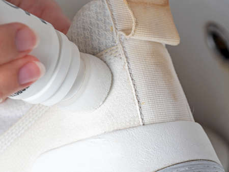 Dirty white sneakers are cleaned with a close-up tool. Concept of Shoe care at homeの写真素材
