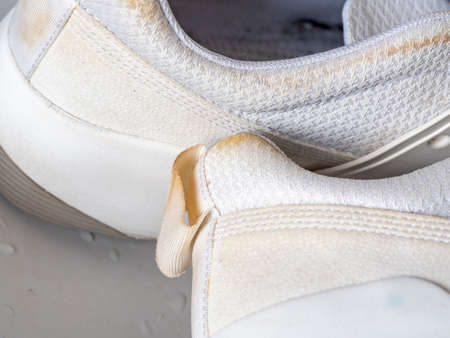 Dirty white sneakers wash in the sink. The concept of Shoe care at homeの写真素材