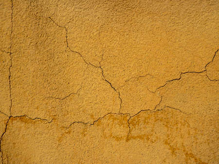 wall painted with orange paint with cracks
