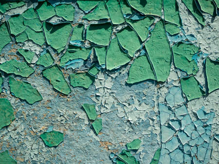 the old weathered peeling paint is green on the wall. Close-up, background, texture
