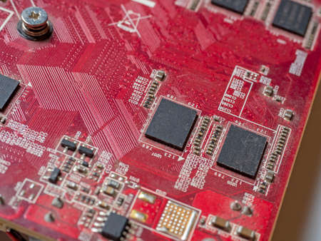 red circuit board with chips and capacitors. Electronic board close-up