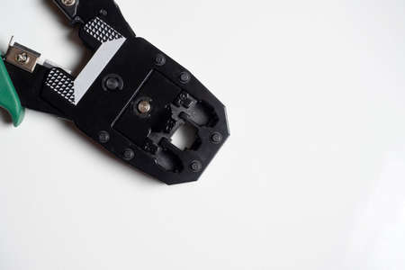Crimping pliers for rj45 internet cables on a white background. Selective focus, copy space, tools for preparing communicationsの写真素材