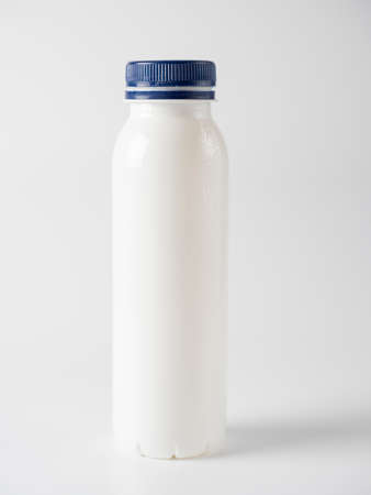 closed plastic milk bottle with blue lid isolated on a white background. Label space, copy space, front view. Plastic recyclingの写真素材