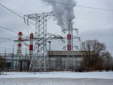 winter city landscape. The smoking pipe of a thermal power plant. steam clubs, electric line....