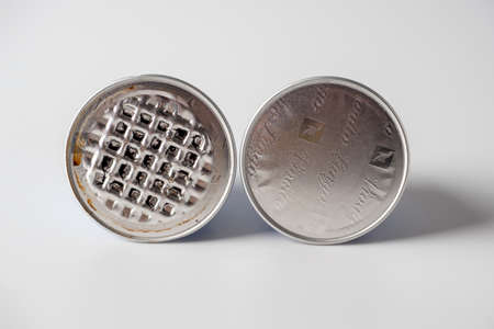 03/04/2021 Russia, Moscow. Two aluminum capsules with ground nespresso coffee on a white background. One capsule used. Delicious aromatic drink. Recycling, wasteのeditorial素材