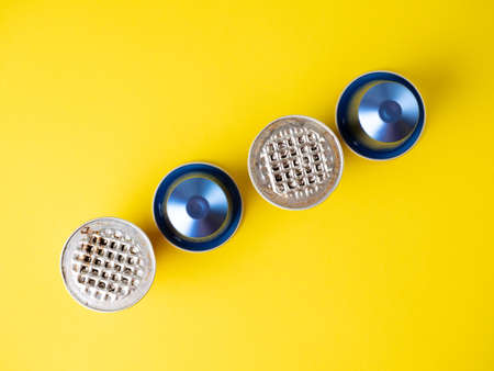 aluminum capsules with ground coffee on a yellow background. several of them are used. The concept of modern solutions for the storage and reuse of products. Top view, flat layのeditorial素材