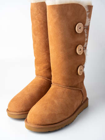 10.04.2021 Russia, Moscow. Close-up of UGG high Sheepskin boots on a white background. Warm shoes,...