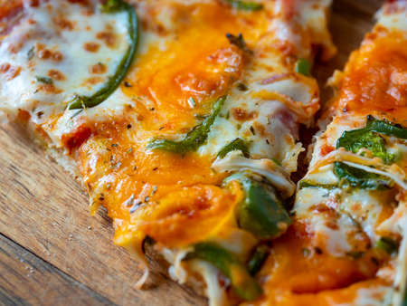 Close-up of a hanging piece of delicious juicy pizza. A traditional Italian dishの写真素材