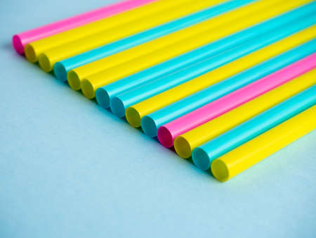 Close-up of multicolored plastic tubes on a blue paper background.