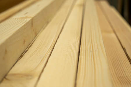 Close-up planed boards lying in a pile. Side view, lumber for construction. Selective focusの写真素材
