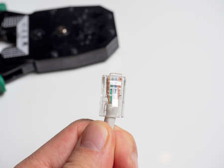 a man is holding a communication cable for connecting the Internet. In the background, cable...