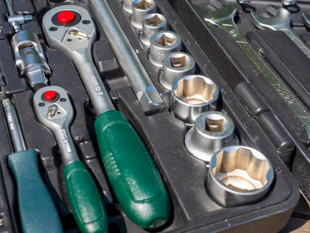 A close-up of a set of tools for repairing a car and other things. wrenches, bits, attachments. Side...
