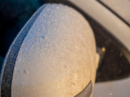Close-up of the side mirror of a white car covered with frost.の写真素材