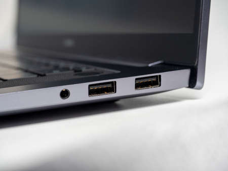 Close-up of a part of a laptop standing on a light background. Large USB ports on the laptop. open laptopの写真素材