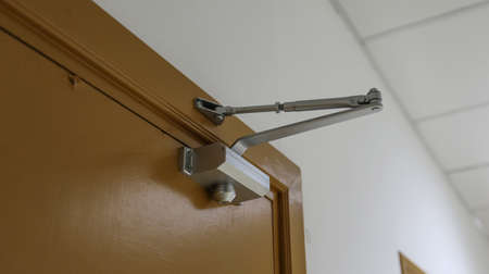 Door closer keeps a glass door close.の写真素材