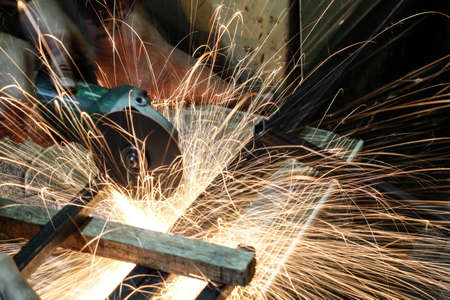  Worker cutting metal with grinder. Sparks while grinding ironの写真素材