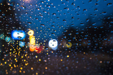 Water drop at car windshield and bokeh of city