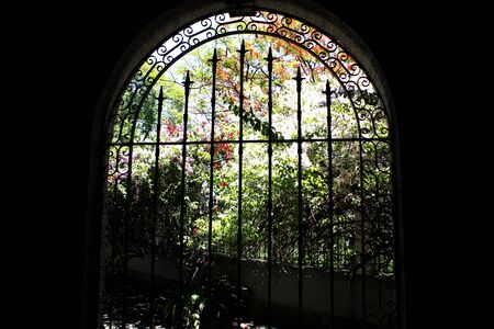 Church window looks like stained glass with garden in the background.の写真素材