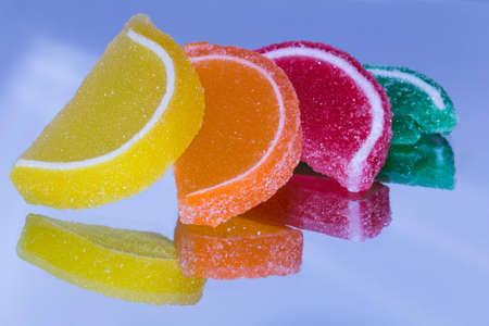 Candied fruit slices on a mirror for reflection.の写真素材