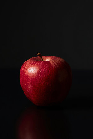 Red apple with water drops on a black background. Studio shot.