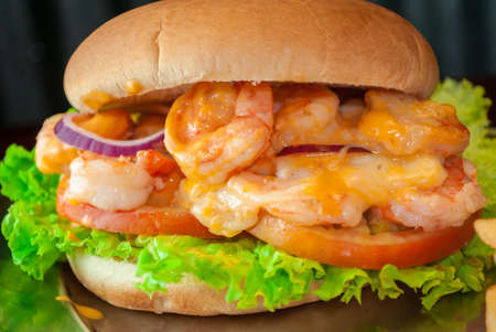 Burger with onion and cheese and fries on black backgroundの写真素材