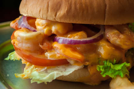 Shrimp Burger with onion and cheese and fries on black backgroundの写真素材
