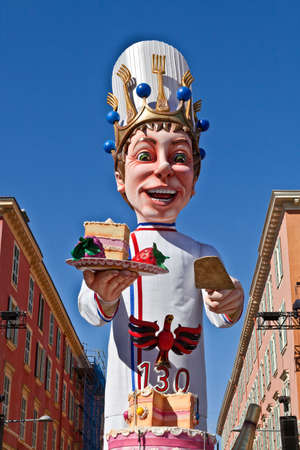 NICE - FRANCE - March 03, 2014: King of carnival 2014. The theme of Nice carnival is the gastronomy. The pastry-cook advancing with his huge cake, offering one slice on the plateのeditorial素材
