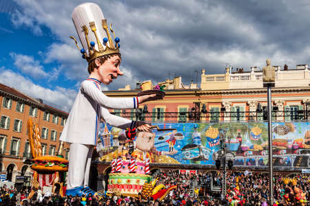 NICE - FRANCE - March 03, 2014: King of carnival 2014. The pastry-cook advancing with his huge cake, offering one slice on the plateのeditorial素材