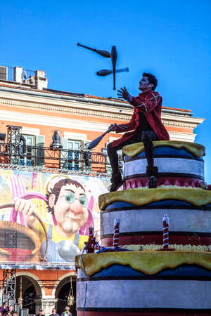 NICE - FRANCE - March 03, 2014: King of carnival 2014. The theme of Nice carnival is the gastronomy. An acrobat playing sitting on a huge cakeのeditorial素材