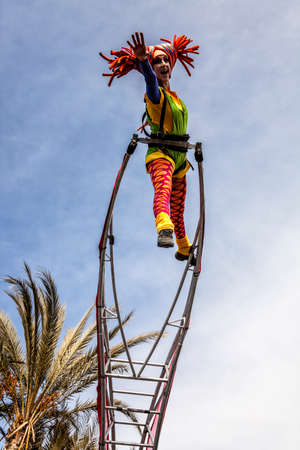 NICE - FRANCE - March 01, 2014: Carnival of Nice, Flowers' battle. An acrobat woman with clown costumeのeditorial素材