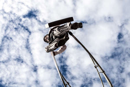 NICE - FRANCE - March 01, 2014: Carnival of Nice, Flowers' battle.  An acrobat in businessman suit walking in the skyのeditorial素材