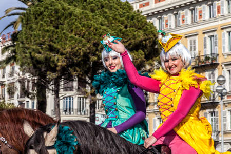 NICE - FRANCE - March 01, 2014: Carnival of Nice, Flowers' battle. Two english riders in costume greet the audienceのeditorial素材