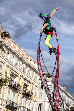 NICE - FRANCE - March 01, 2014: Carnival of Nice, Flowers' battle. An acrobat woman with clown costume のeditorial素材