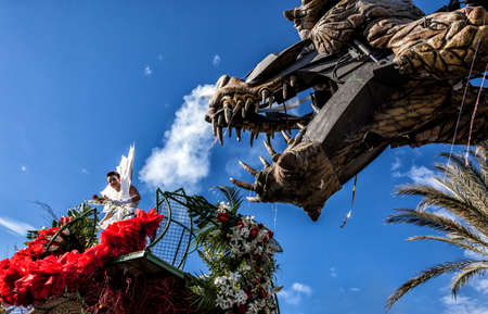 NICE - FRANCE - March 01, 2014: Carnival of Nice, Flowers' battle. 
Young woman dressed in white and a dragonのeditorial素材