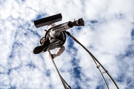 NICE - FRANCE - March 01, 2014: Carnival of Nice, Flowers' battle.  An acrobat in businessman suit walking in the skyのeditorial素材