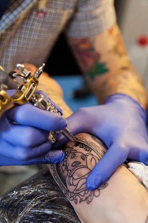 Como, ITALY - 17 May 2013.Close-up on tattoo machine make drawing of a woman's face. Como Lakeのeditorial素材