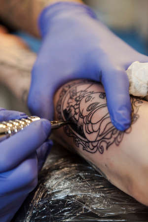 Como, ITALY - 17 May 2013. Close-up on tattoo machine make drawing of a woman's face. Como Lakeのeditorial素材