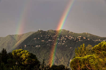 Double rainbow over the mountain overlooking Como. City of Brunate in summertime. Como Lake. Italyの写真素材