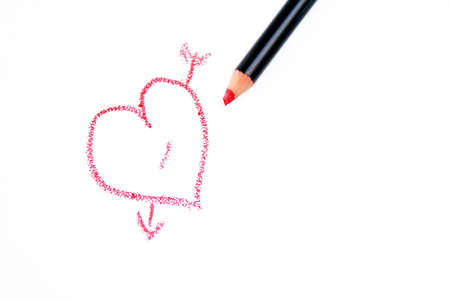 \r\na heart with an arrow through it drawn with a red pencil on a white background.の写真素材