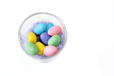 
colorful easter eggs in a glass dish isolated on white background
