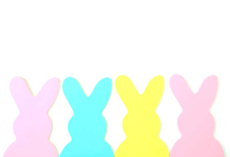 Easter bunnies shapes made of construction paper and lined up on a white background as a boarder.の写真素材