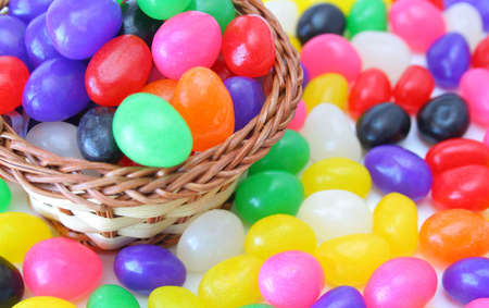 Jelly beans in a basket sitting on a layer of jelly beans